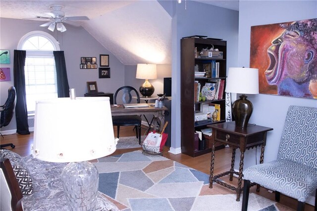 home office featuring ceiling fan, light hardwood / wood-style flooring, and lofted ceiling