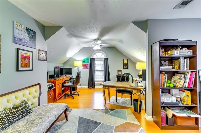 office featuring ceiling fan, hardwood / wood-style floors, and vaulted ceiling