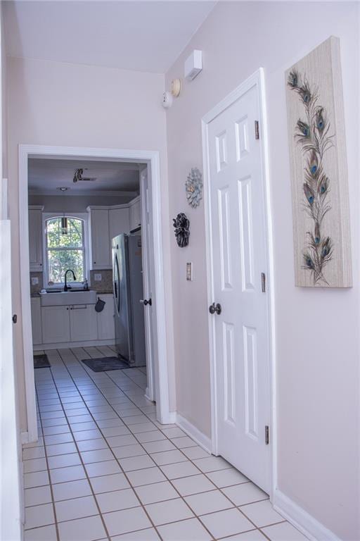 hall with washer / dryer, light tile patterned floors, and sink