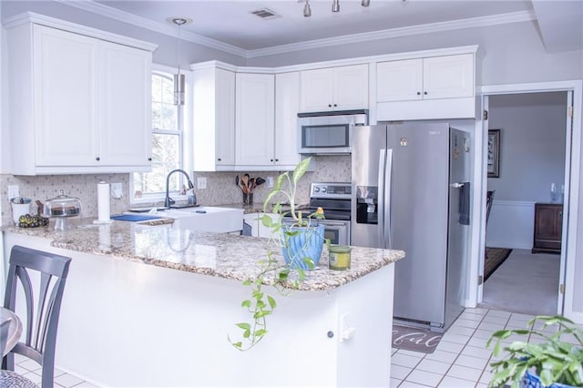 kitchen featuring kitchen peninsula, white cabinetry, stainless steel appliances, and decorative light fixtures