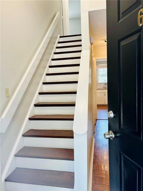 stairway featuring parquet flooring and sink