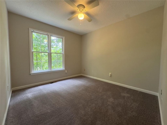 671 Peach Crossing Dr, Dallas, GA 30132 - empty room featuring a textured ceiling, dark colored carpet, and a ceiling fan
