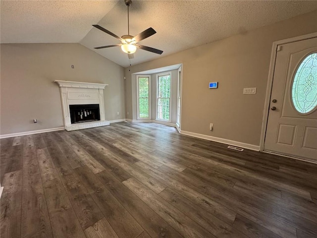 671 Peach Crossing Dr, Dallas, GA 30132 - unfurnished living room with a ceiling fan, dark wood finished floors, a textured ceiling, lofted ceiling, and a glass covered fireplace