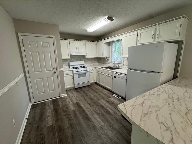 671 Peach Crossing Dr, Dallas, GA 30132 - kitchen featuring white appliances, white cabinets, under cabinet range hood, tasteful backsplash, and dark wood-style flooring