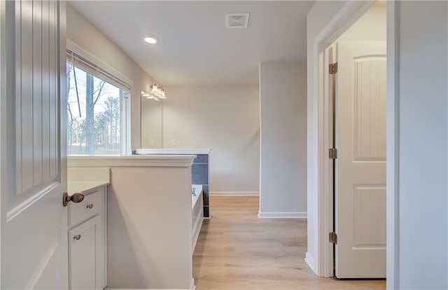 interior space with light hardwood / wood-style floors and white cabinets