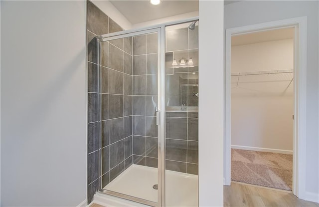 bathroom featuring wood-type flooring and a shower with door