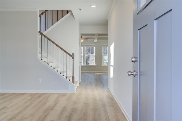 entrance foyer with beamed ceiling, light wood-type flooring, ceiling fan, crown molding, and coffered ceiling