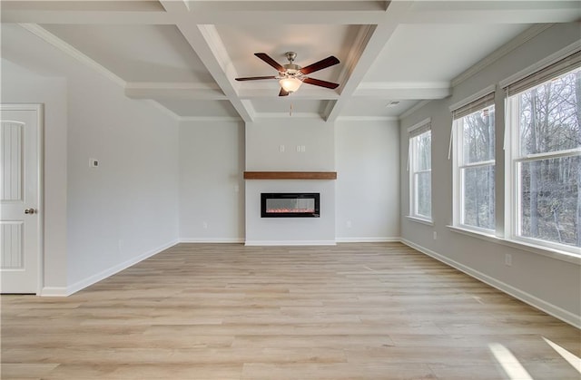 unfurnished living room with coffered ceiling, light wood-type flooring, beamed ceiling, and a wealth of natural light