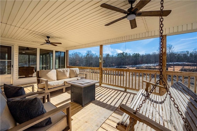 wooden deck featuring an outdoor living space with a fire pit and ceiling fan