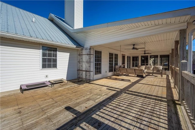 wooden terrace with ceiling fan and an outdoor living space