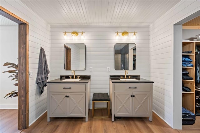 bathroom with hardwood / wood-style flooring, walk in shower, and vanity