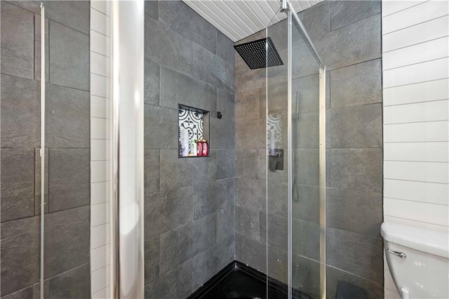 bathroom with toilet and a tile shower