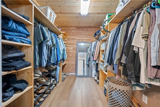 walk in closet with light hardwood / wood-style flooring