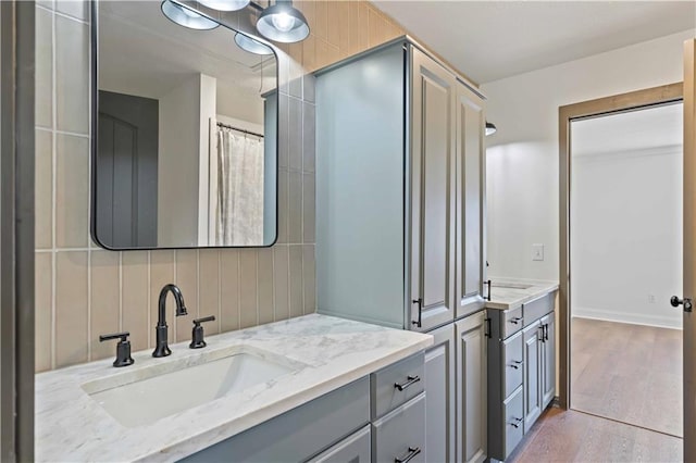 bathroom with a shower, vanity, tasteful backsplash, and hardwood / wood-style flooring