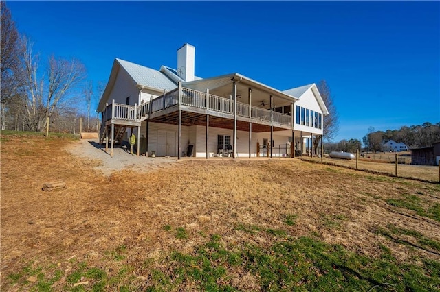 rear view of house with ceiling fan, a sunroom, and a wooden deck