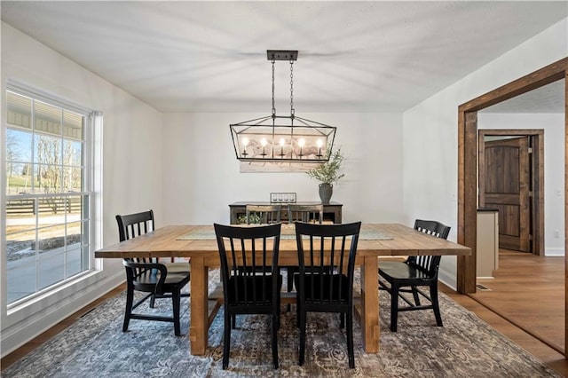 dining area with wood-type flooring and a chandelier