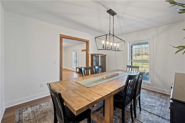 dining room with a notable chandelier and dark hardwood / wood-style flooring