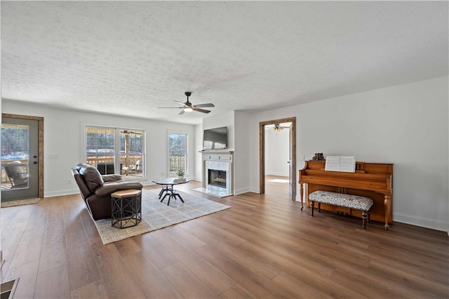 living room featuring a textured ceiling, ceiling fan, and wood-type flooring