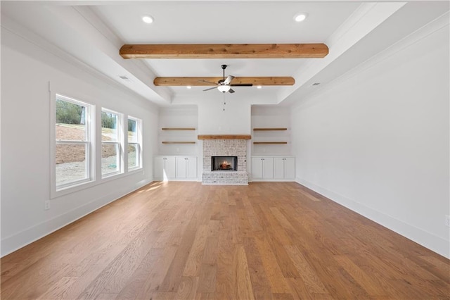 unfurnished living room with light wood finished floors, baseboards, beam ceiling, recessed lighting, and a fireplace