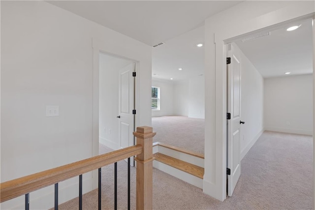 hallway featuring recessed lighting, baseboards, carpet floors, and an upstairs landing