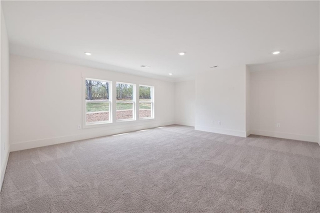 spare room featuring recessed lighting, baseboards, and light carpet