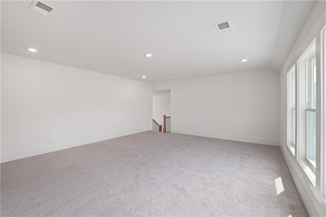 carpeted spare room with plenty of natural light, recessed lighting, baseboards, and visible vents