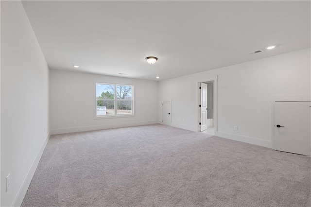 spare room with recessed lighting, baseboards, visible vents, and light carpet