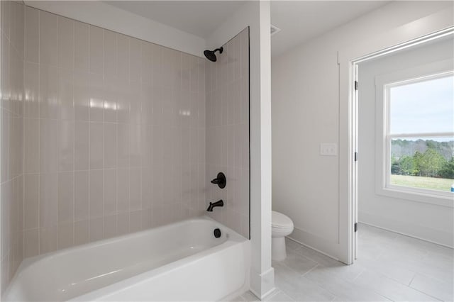 bathroom with tile patterned flooring, toilet, baseboards, and washtub / shower combination