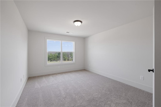 spare room featuring carpet flooring, baseboards, and visible vents