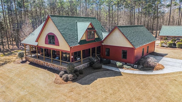 view of front of house with driveway, roof with shingles, crawl space, a porch, and a front yard