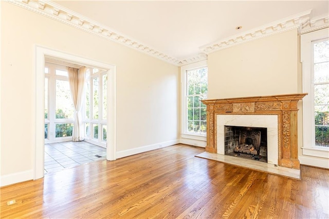 unfurnished living room with a premium fireplace, hardwood / wood-style floors, and ornamental molding