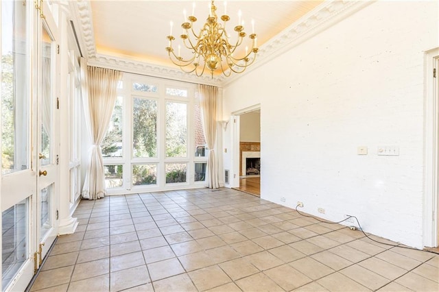 interior space featuring light tile patterned flooring, crown molding, and a chandelier