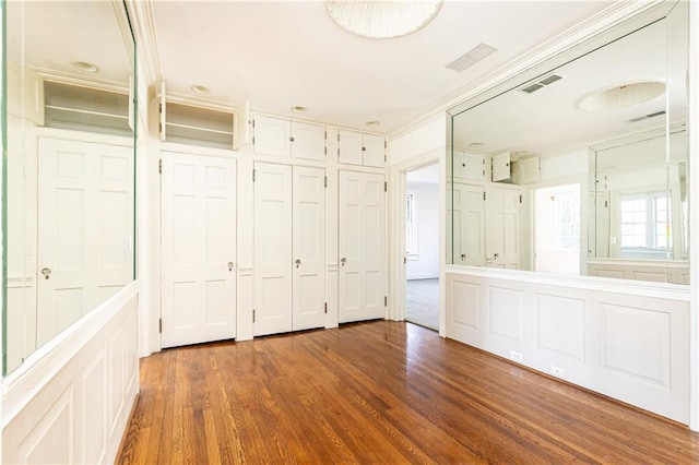 unfurnished bedroom with crown molding and dark hardwood / wood-style floors