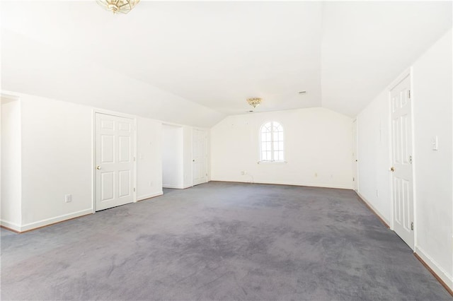 bonus room featuring dark colored carpet and lofted ceiling