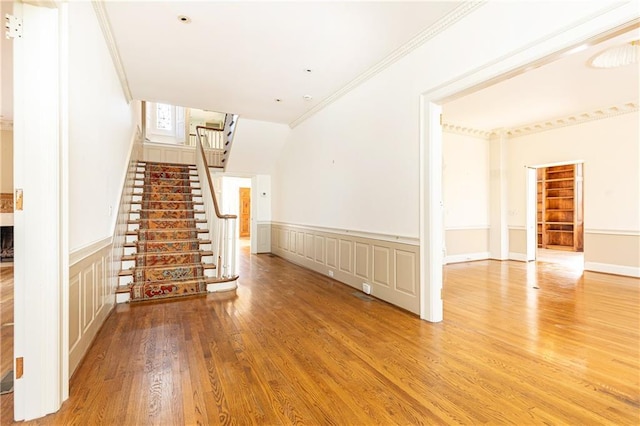 unfurnished living room featuring light hardwood / wood-style floors and crown molding