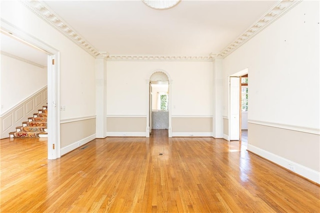 empty room with hardwood / wood-style flooring and crown molding