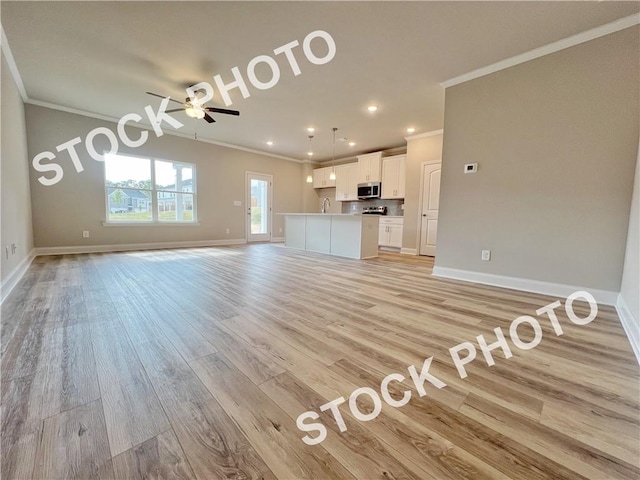 unfurnished living room with crown molding, baseboards, ceiling fan, and light wood finished floors