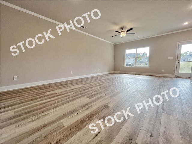 unfurnished living room with ornamental molding, a wealth of natural light, baseboards, and wood finished floors