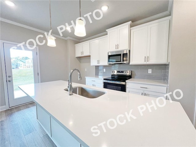 kitchen with crown molding, stainless steel appliances, backsplash, white cabinetry, and a sink