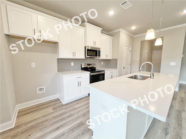 kitchen with light wood-style flooring, stainless steel appliances, a sink, visible vents, and backsplash