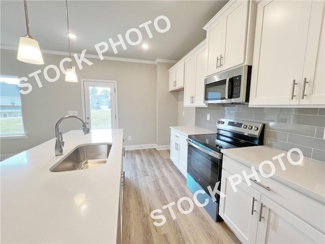 kitchen featuring stainless steel appliances, white cabinetry, a sink, and backsplash