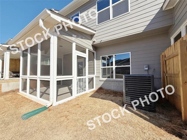 view of home's exterior with a sunroom and central AC unit