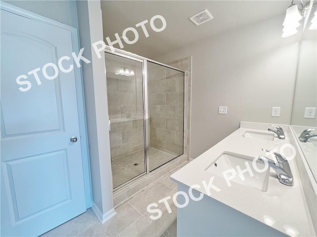 bathroom with a sink, visible vents, tile patterned floors, double vanity, and a stall shower