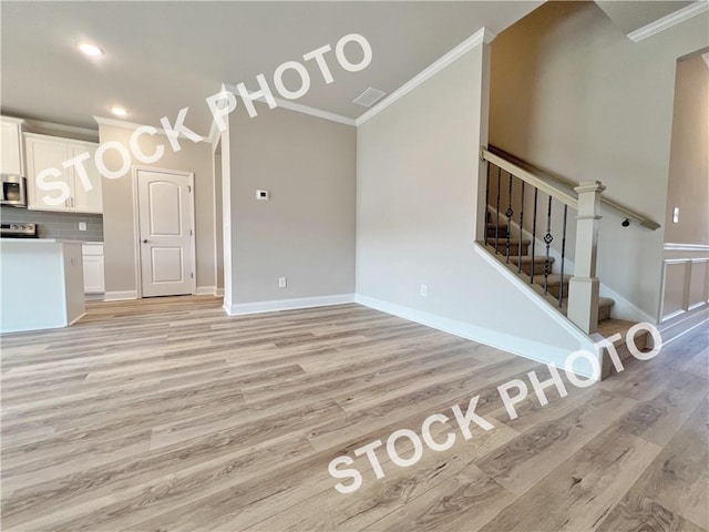 kitchen featuring appliances with stainless steel finishes, white cabinets, ornamental molding, and backsplash