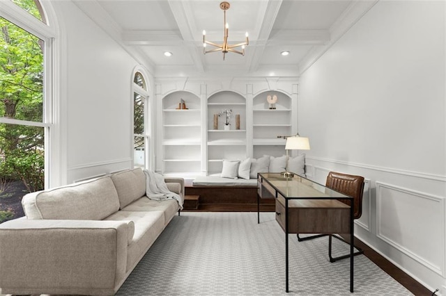 living area with a chandelier, coffered ceiling, beamed ceiling, built in features, and a decorative wall