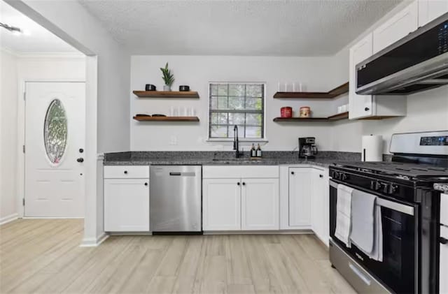 kitchen with appliances with stainless steel finishes, sink, and white cabinets