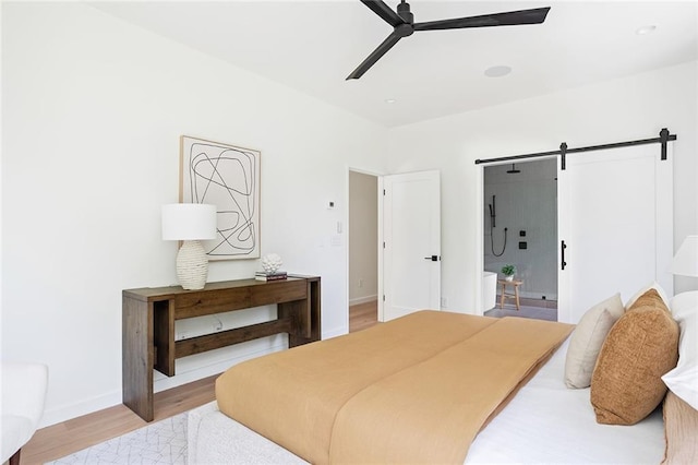 3117 Robinson Ave, Scottdale, GA 30079 - bedroom with a barn door, light wood-type flooring, baseboards, and ceiling fan