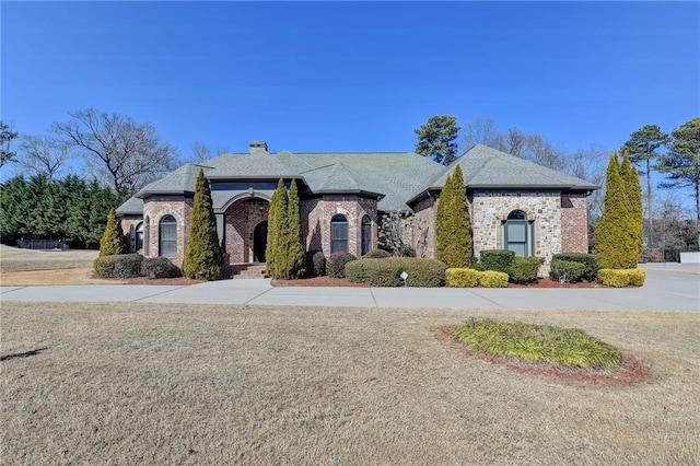 french country style house featuring a front lawn