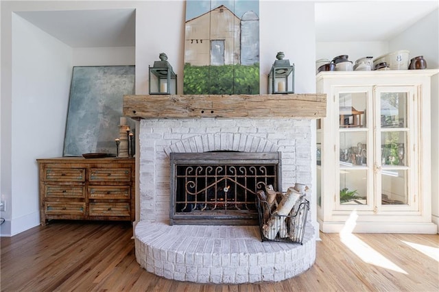 room details with baseboards, wood finished floors, and a fireplace