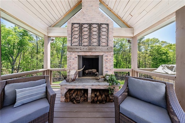 wooden deck featuring an outdoor brick fireplace